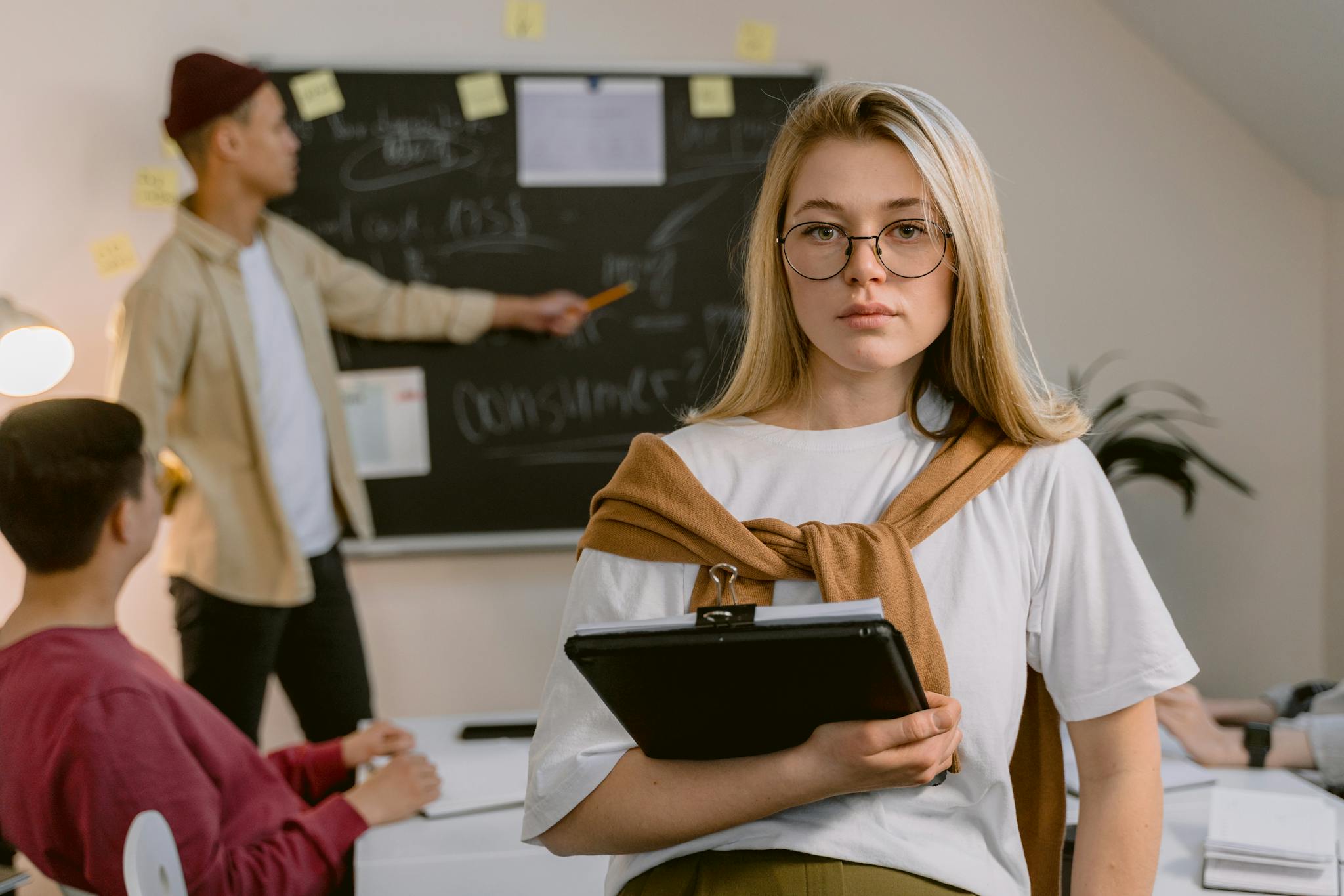 Business team engaged in project planning with blackboard and tablet in modern office.
